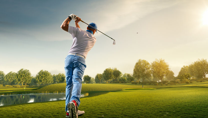 a man hitting a golf ball at a golf course