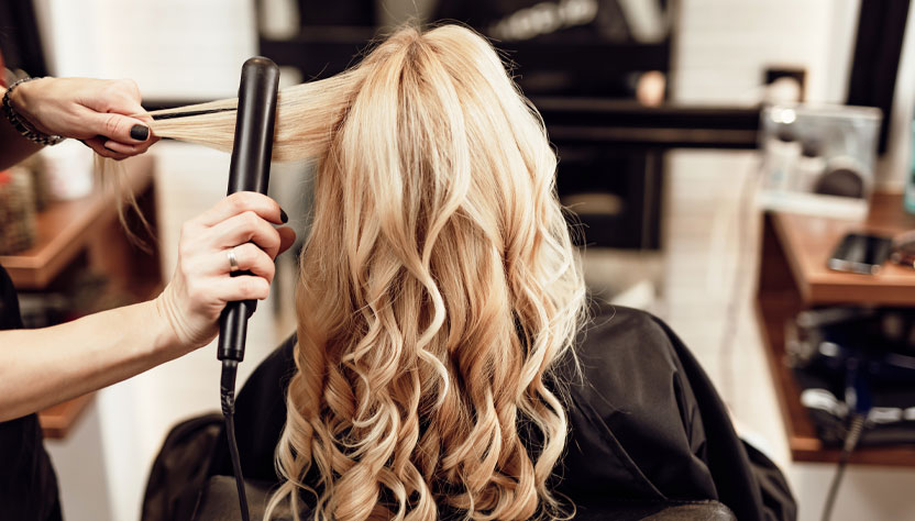 a hairdresser curling a customer's hair